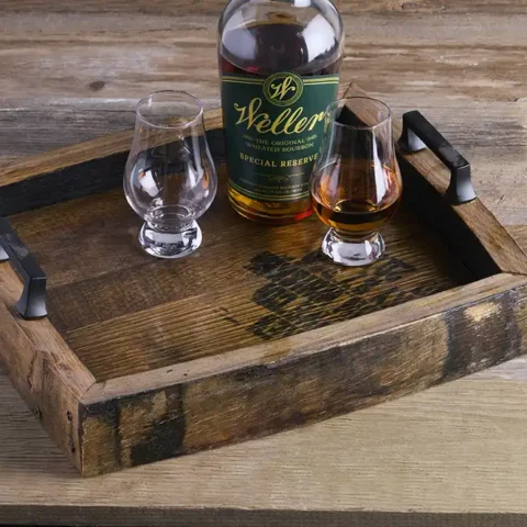 Whiskey barrel serving tray with bourbon bottle and glasses on it.